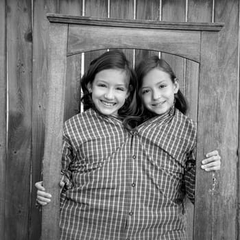 twin girls fancy dressed up pretending be siamese with dad shirt playing with grunge border frame