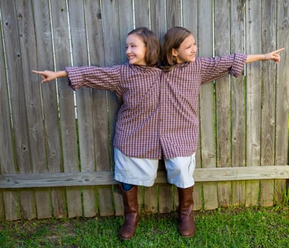 twin girls fancy dressed up pretending be siamese with his father shirt pointing finger