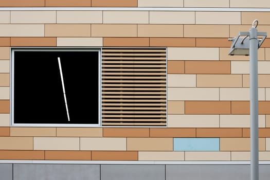 The photograph of a lantern in front of a modern house façade.