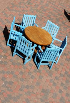 The photograph of a round wooden table with chairs.