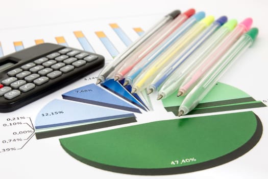 Business chart with a calculator and pile of colored pens