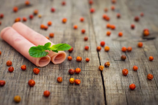 Fresh ham rolls with a mint leaf on wood background