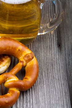 Beer and pretzels on a rustic wooden table with text space on the right side