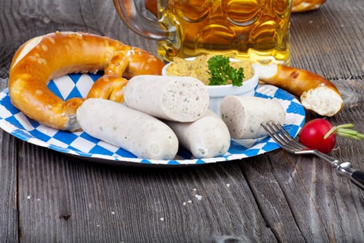 White sausage with mustard,pretzel and a beer on a rustic wooden table