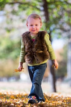 cute little girl with autumn leaves
