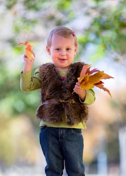 cute little girl with autumn leaves
