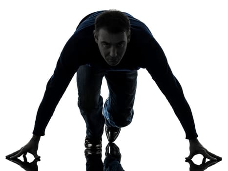 one caucasian man starting blocks full length in silhouette studio isolated on white background