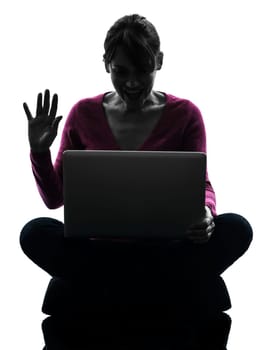 one caucasian woman saluting computing laptop computer  in silhouette studio isolated on white background
