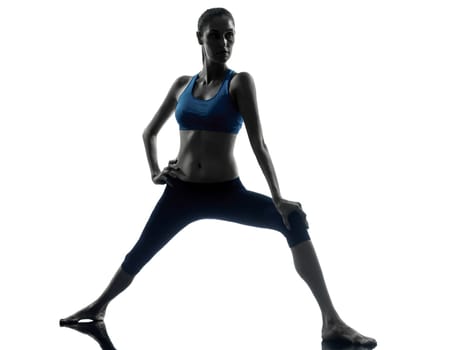 one caucasian woman exercising yoga warrior position in silhouette studio isolated on white background