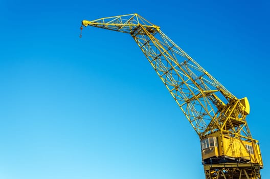 Old yellow crane set against a blue sky