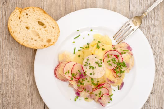 Potato salad with sausage,radishes and chives