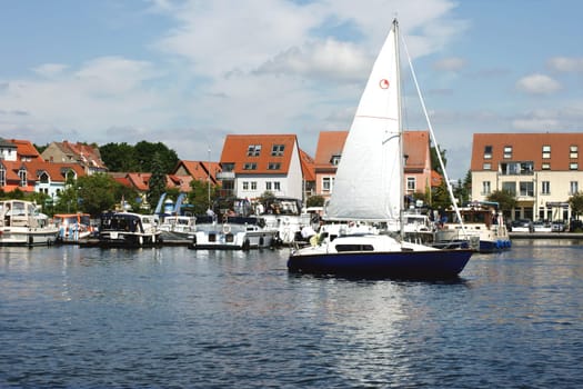 Waren,Mecklenburg Vorpommern/Germany – June 09,2013: A sailing ship with unknown persons leaves the boat harbour of the city of Waren an der Müritz on June 9th in Waren.