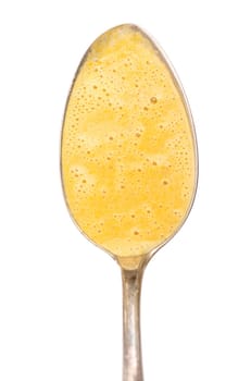 White spoon with foamed soup of carrots