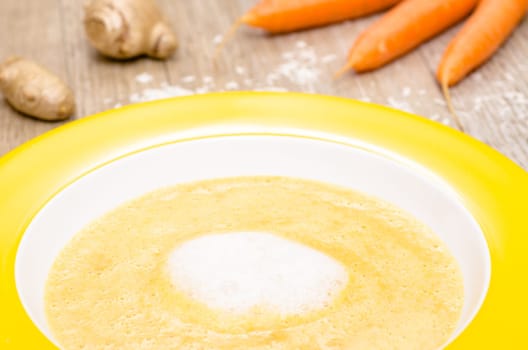 Frothed carrot soup with coconut milk in a plate