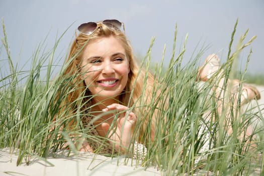 Young woman lies in the dunes