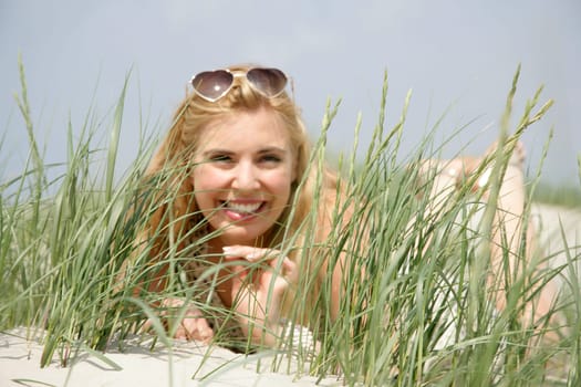 Young woman lies in the dunes