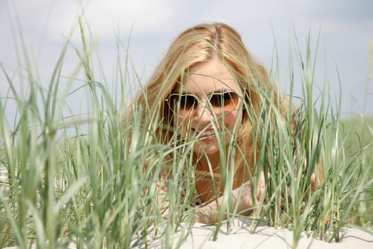Young woman lies in the dunes