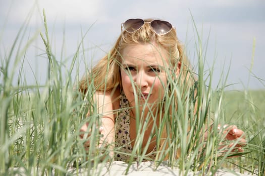 Blonde woman lies in the dunes