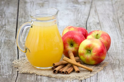Apple juice and apples on wooden background