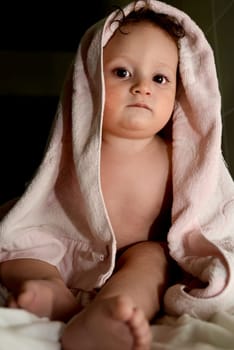 Baby after bath wrapped in a soft cloth with a relaxed expression