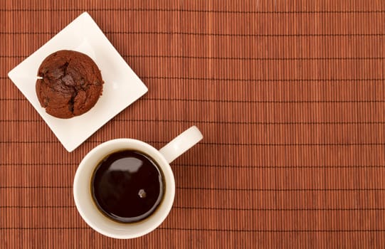 Chocolate Muffins on a white plate with  a cup of coffee.