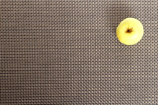Green apple on a placemat, background.