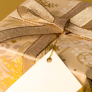 Gold Christmas gift with blank label wishing card
