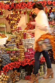 Blurry woman buyer shopping Christmas decorations at shop