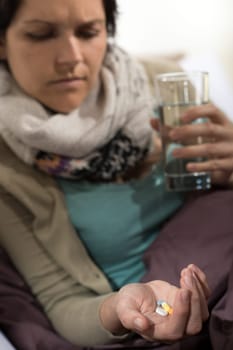Sick woman taking pills for flu