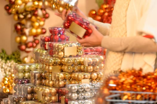 Buyer shopping shiny Christmas balls in plastic boxes