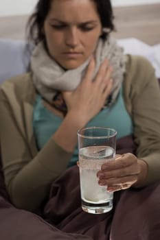 Sick woman preparing cold flu medicine to drink