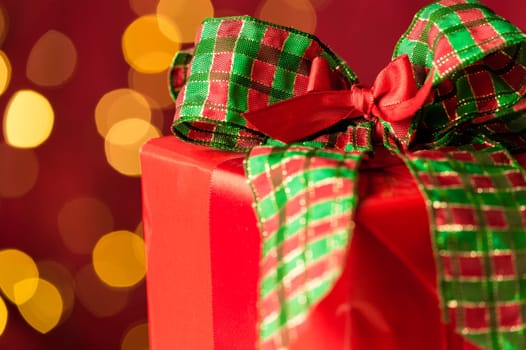 Christmas gift and sparkling defocused lights background red and green