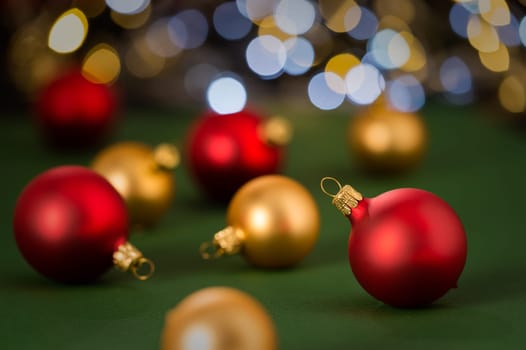 Christmas red and golden baubles on green color paper in the background