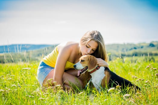 Young woman kissing her dog - outdoor in nature