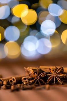 Christmas spices clove, star anise and cinnamon sparkling lights background