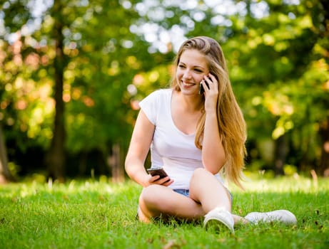 Young beautiful woman (teen girl) with 2 mobile phones - mobility concept