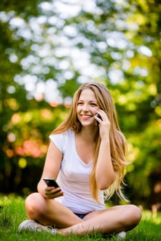 Teenage girl with 2 mobile phones - mobility and multitasking concept