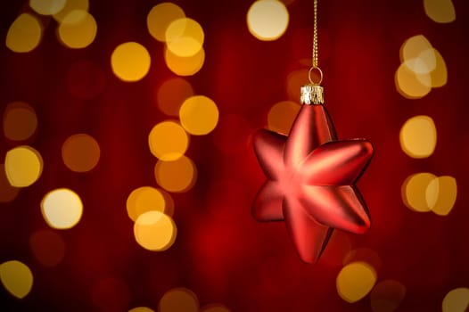 Hanging Christmas Ornament star with sparkling lights in background