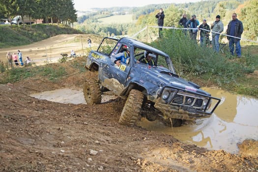 MOHELNICE, CZECH REPUBLIC - OCT 05. Black car is passing through  a puddle of mud on a trial race in the "BIG SHOCK CUP Trial 2013"" on October 05, 2013 in Mohelnice, Czech Republic."