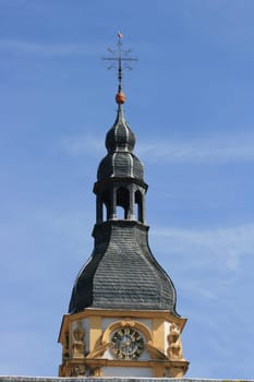 Church tower with a beautiful clock and blue sky in the background