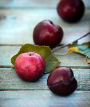 Close-up of just harvested fresh tasty cherries with leaves on a wooden table