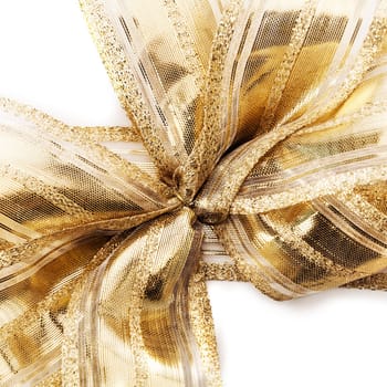Luxury gold ribbon with a rich metallic shine tied into a bow on festive packaging or a gift for a holiday, festival, party, or anniversary, closeup overhead view