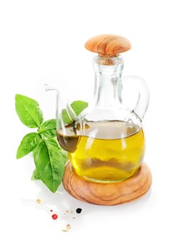 Olive oil cruet with basil leafs and pepper grains