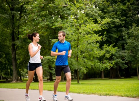 Young couple jogging outdoor and looking on each other