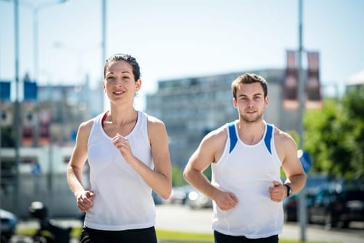 Young sport couple jogging together in city environment
