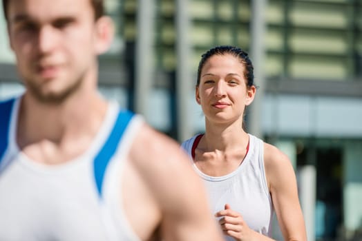 Young sport couple jogging in city environment - man cropped