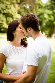 Young happy couple kissing - outdoor lifestyle portrait