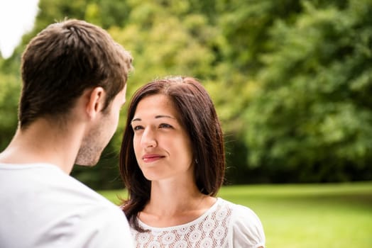 Young happy couple looking on each other - outdoor lifestyle portrait