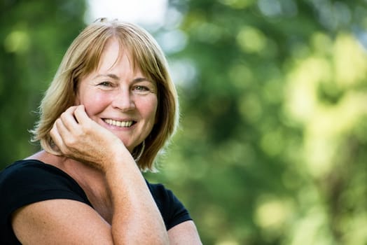 Portrait of happy smiling senior woman - outside on sunny day