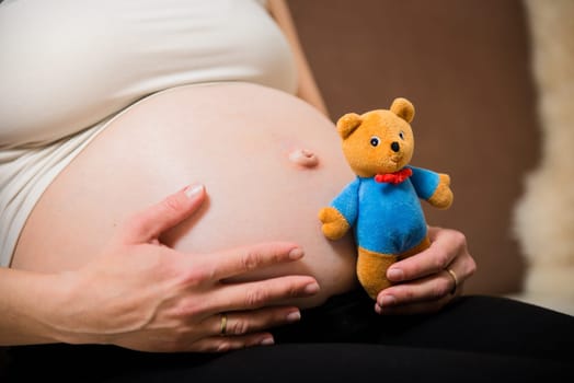 Detail of hands holding pregnant belly - with
